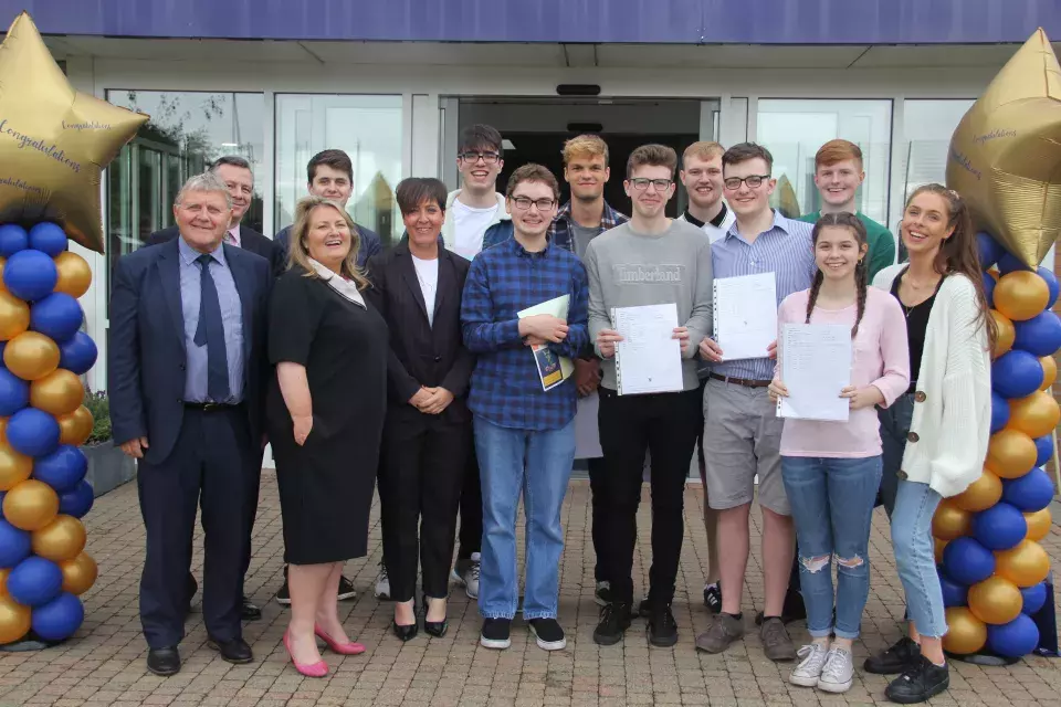 Antrim Grammar School pupils and staff celebrating A level results with Education Authority representatives