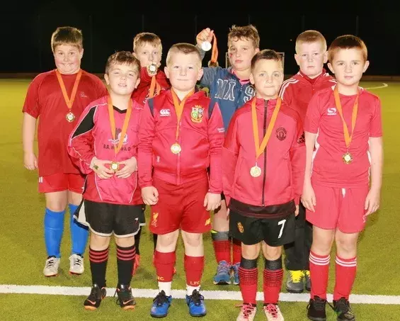 Football players with medals at the opening of the Augher community's MUGA pitch