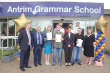 Principal of Antrim Grammar School with pupils celebrating A and AS level results with representatives from Education Authority