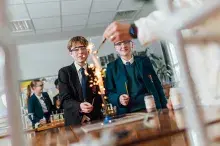Image of two pupils watching an experiment on a bunsen burner