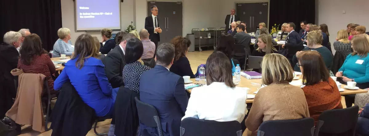 Audience of local school leaders listen to welcome to round table event