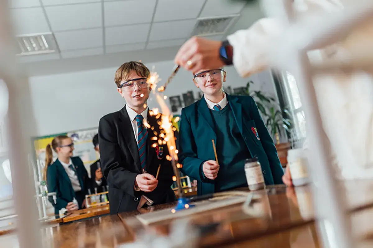 Image of two pupils watching an experiment on a bunsen burner
