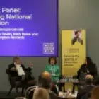 Mark Baker, Chief Executive, CSSC sitting with three other panel members. Expert Panel:Forging National Cohesion is written on a screen behind Mark Baker