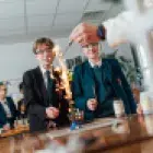 Image of two pupils watching an experiment on a bunsen burner